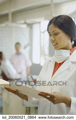 Indian female dentist looking at chart View Large Photo Image Picture - Indian female dentist looking at chart. Fotosearch