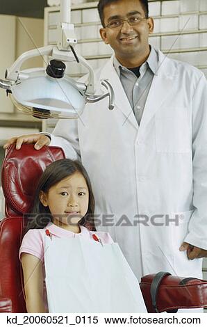 Indian male dentist with Asian girl in dentist's chair View Large Photo Image Stock Photography - Indian male dentist with Asian girl in dentist's chair. Fotosearch