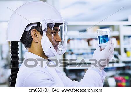 Indian male scientist wearing respirator and looking at beaker View Large Photo Image Stock Photography - Indian male scientist wearing respirator and looking at beaker. Fotosearch