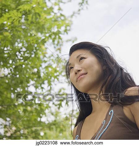 https://fscomps.fotosearch.com/compc/BLD/BLD014/low-angle-view-of-young-asian-woman-stock-photo__jg0223108.jpg