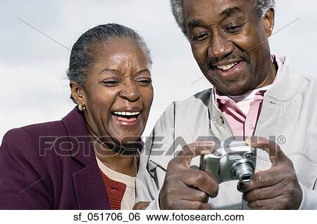Senior African couple smiling and looking at digital camera View Large Photo Image Stock Photograph - Senior African couple smiling and looking at digital camera. Fotosearch