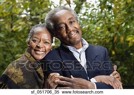 Stock Photography - Senior African couple smiling in woods. Fotosearch