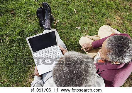 Senior African couple using laptop on grass outdoors View Large Photo Image Stock Image - Senior African couple using laptop on grass outdoors. Fotosearch