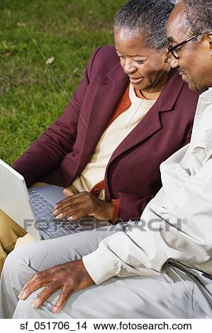 Senior African couple using laptop outdoors View Large Photo Image Picture - Senior African couple using laptop outdoors. Fotosearch