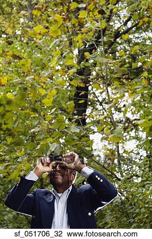 Senior African man using binoculars in woods View Large Photo Image Stock Image - Senior African man using binoculars in woods. Fotosearch