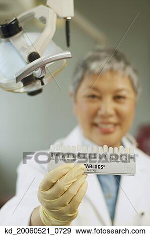 Senior Asian female dentist holding tooth color samples View Large Photo Image Stock Photo - Senior Asian female dentist holding tooth color samples. Fotosearch