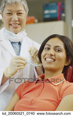 Senior Asian female dentist next to Indian female patient View Large Photo Image Stock Image - Senior Asian female dentist next to Indian female patient. Fotosearch