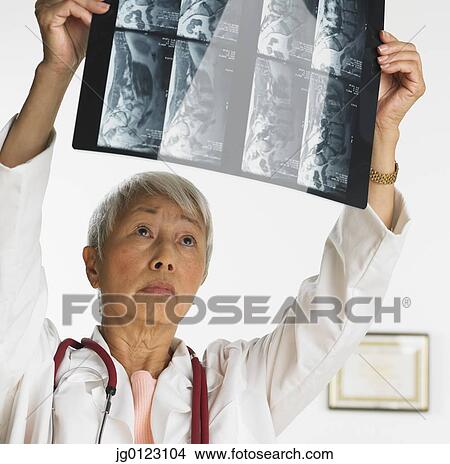 Senior Asian female doctor looking at x-rays View Large Photo Image Picture - Senior Asian female doctor looking at x-rays. Fotosearch