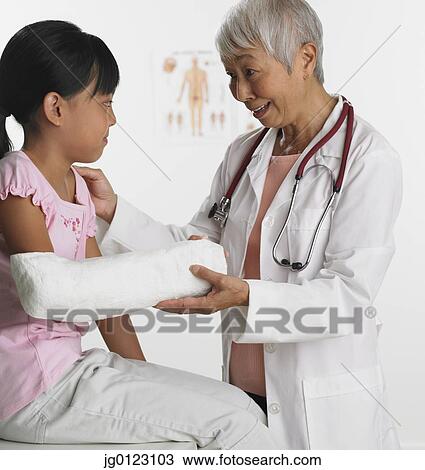 Senior Asian female doctor with young patient View Large Photo Image Stock Image - Senior Asian female doctor with young patient. Fotosearch