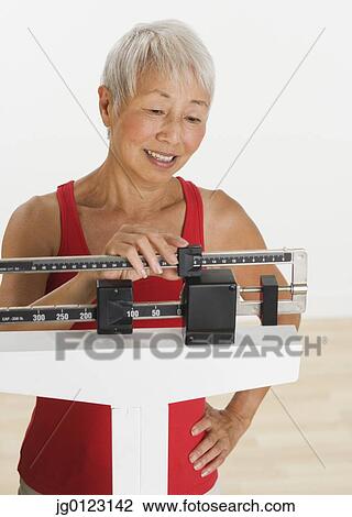 Senior Asian woman adjusting scale View Large Photo Image Stock Image - Senior Asian woman adjusting scale. Fotosearch