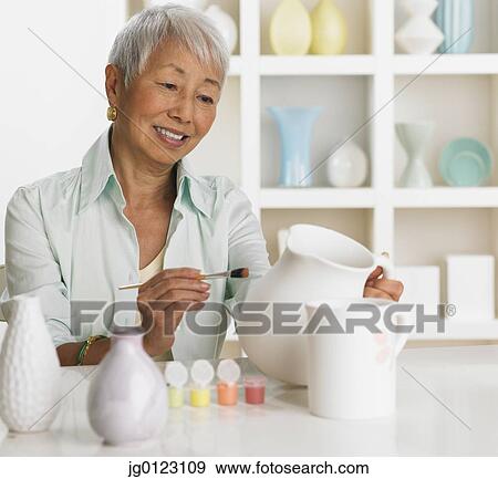 Senior Asian woman painting pottery View Large Photo Image Stock Photo - Senior Asian woman painting pottery. Fotosearch