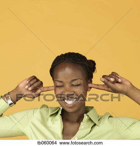 Picture - Studio shot of African woman plugging ears with fingers. Fotosearch