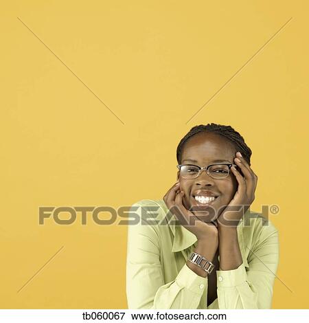 Studio shot of African woman wearing eye glasses and smiling View Large Photo Image Stock Photo - Studio shot of African woman wearing eye glasses and smiling. Fotosearch