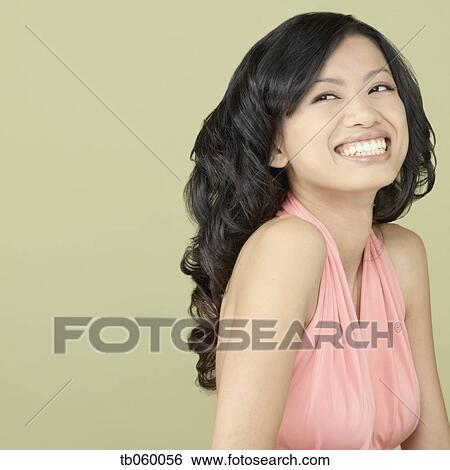 Stock Photograph - Studio shot of Asian woman laughing. Fotosearch