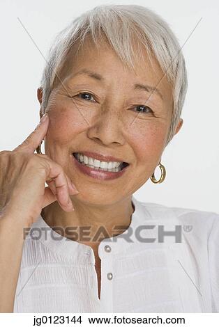 Picture - Studio shot of senior Asian woman smiling. Fotosearch