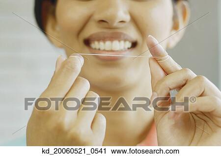 Woman smiling and holding dental floss View Large Photo Image Stock Image - Woman smiling and holding dental floss. Fotosearch