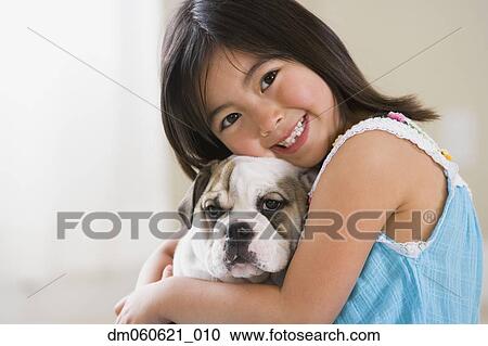 Young Asian girl smiling and hugging puppy View Large Photo Image Stock Image - Young Asian girl smiling and hugging puppy. Fotosearch