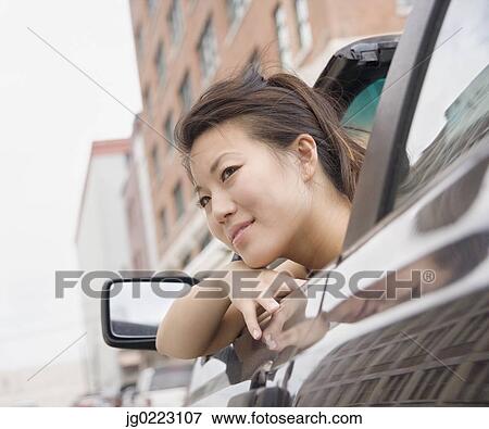 Young Asian woman leaning out of car window View Large Photo Image Stock Photo - Young Asian woman leaning out of car window. Fotosearch