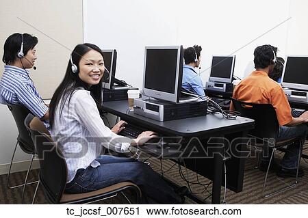 Stock Image - Young computer service technicians with headsets . Fotosearch