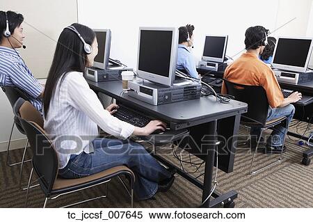 Stock Photography - Young computer service technicians with headsets . Fotosearch
