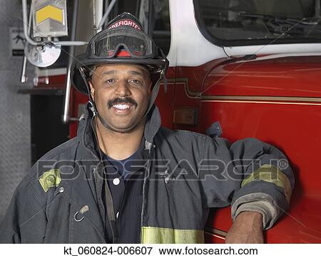 African male firefighter leaning against fire truck View Large Photo Image Stock Photo - African male firefighter leaning against fire truck. Fotosearch