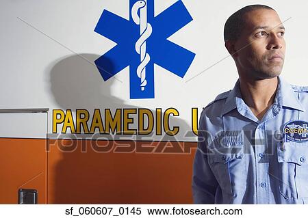 Stock Photography - African male paramedic standing next to ambulance. Fotosearch