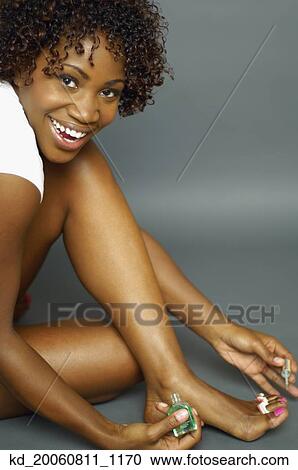 African woman smiling and painting toenails View Large Photo Image Stock Image - African woman smiling and painting toenails. Fotosearch