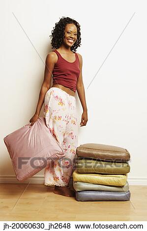 African woman smiling next to stack of pillows View Large Photo Image Stock Photo - African woman smiling next to stack of pillows. Fotosearch