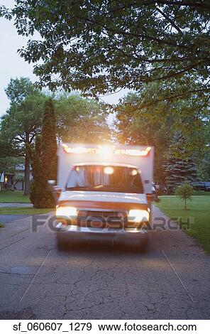 Stock Photo - Ambulance with lights on driving in residential area. Fotosearch