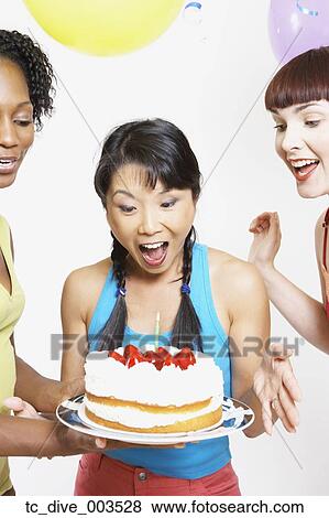 Stock Photo - Asian woman getting cake with candle. Fotosearch