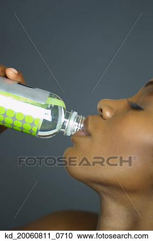 Close up of African woman drinking bottle of water View Large Photo Image Stock Image - Close up of African woman drinking bottle of water. Fotosearch