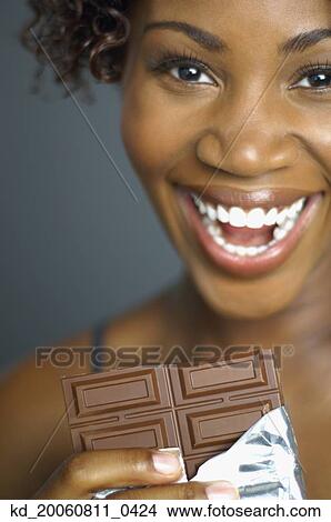 Close up of African woman eating chocolate View Large Photo Image Picture - Close up of African woman eating chocolate. Fotosearch