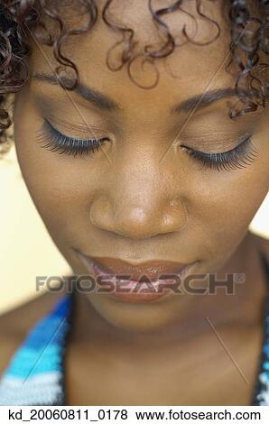 Close up of African woman looking down View Large Photo Image Stock Photo - Close up of African woman looking down. Fotosearch