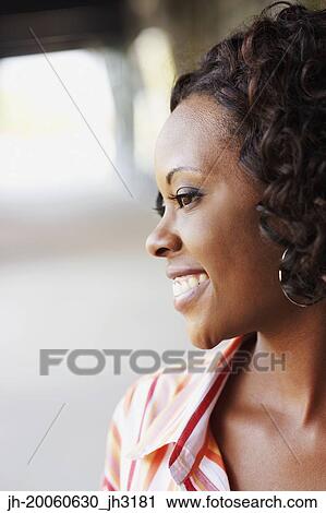 Stock Image - Close up of African woman smiling outdoors. Fotosearch