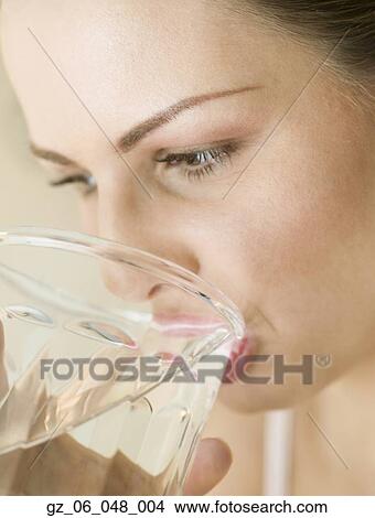 Picture - Close up of woman drinking glass of water. Fotosearch