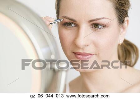 Close up of woman tweezing eyebrows View Large Photo Image Stock Image - Close up of woman tweezing eyebrows. Fotosearch