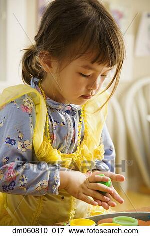 Stock Photo - Close up of young Asian girl playing with clay. Fotosearch