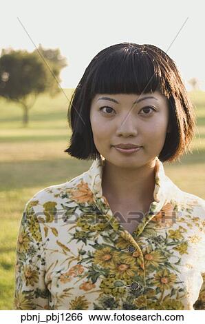 Close up of young Asian woman outdoors View Large Photo Image Stock Photograph - Close up of young Asian woman outdoors. Fotosearch