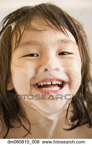 Close up of young girl smiling with soap suds on face View Large Photo Image Stock Photo - Close up of young girl smiling with soap suds on face. Fotosearch