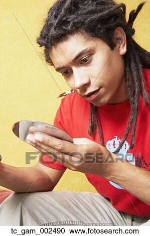 Close up of young Hispanic man looking at cd View Large Photo Image Stock Image - Close up of young Hispanic man looking at cd. Fotosearch
