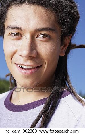 Close up of young Hispanic man smiling outdoors View Large Photo Image Stock Image - Close up of young Hispanic man smiling outdoors. Fotosearch