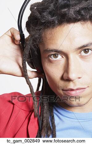 Stock Photo - Close up of young Hispanic man wearing headphones. Fotosearch