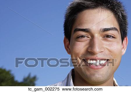 Stock Photography - Close up of young man smiling outdoors. Fotosearch