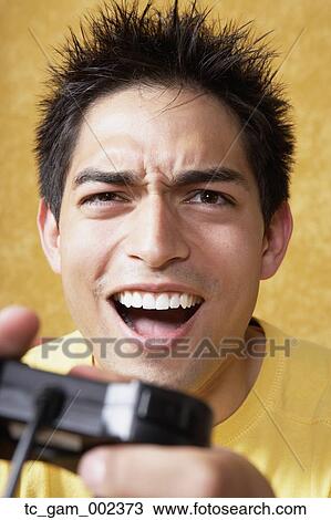Stock Image - Close up young man playing video games. Fotosearch