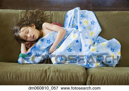 Stock Photo - High angle view of young Asian girl sleeping on sofa. Fotosearch