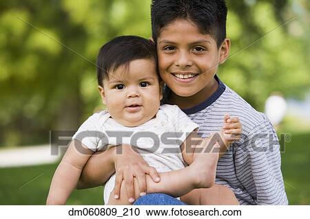 Hispanic boy holding baby sibling outdoors View Large Photo Image Stock Image - Hispanic boy holding baby sibling outdoors. Fotosearch