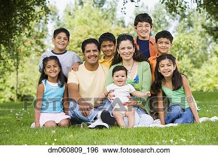 Stock Photograph - Hispanic family sitting outdoors smiling. Fotosearch