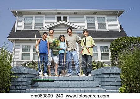 Stock Image - Hispanic family standing on steps in front of house. Fotosearch