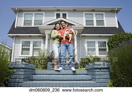 Stock Photograph - Hispanic family standing on steps in front of house. Fotosearch