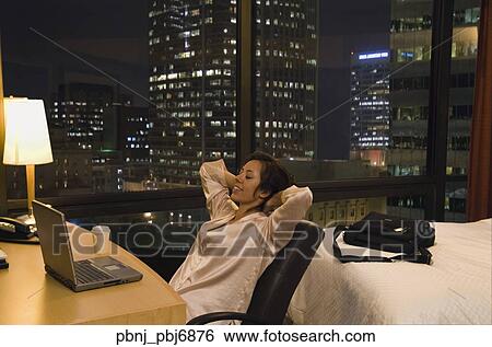 Hispanic woman using laptop in hotel room View Large Photo Image Stock Photograph - Hispanic woman using laptop in hotel room. Fotosearch